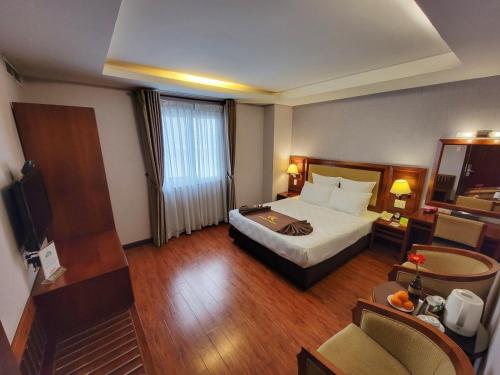 a hotel room with a bed and a television at Aristo Saigon Hotel in Ho Chi Minh City