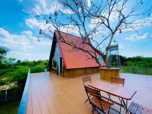a wooden deck with a wooden table and chairs at HaiVen Farm Homestay in Phumĭ Khŭn Réam