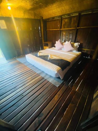 a bedroom with a bed in a wooden room at HaiVen Farm Homestay in Phumĭ Khŭn Réam