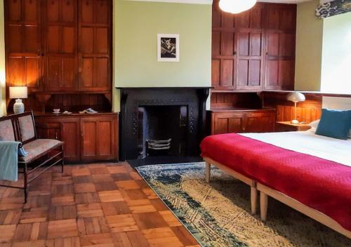 ポルスマドグにあるThe Manor Cricciethのベッドルーム(ベッド1台、暖炉付)