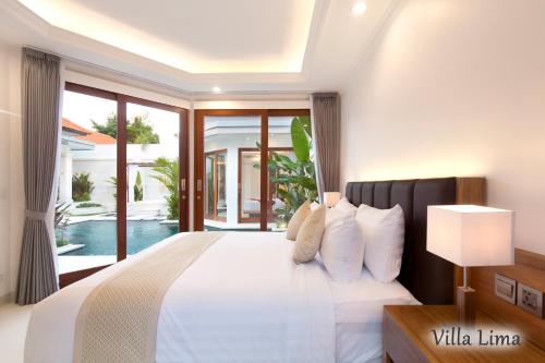 a bedroom with a white bed and a large window at Villa Mia Seminyak - Boutique Villas in Seminyak
