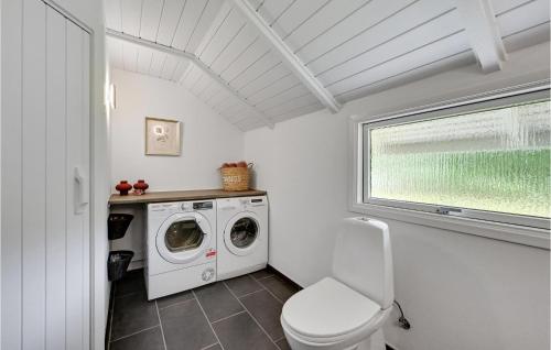 La salle de bains est pourvue d'un lave-linge et de toilettes. dans l'établissement Amazing Home In Oksbl With Sauna, à Oksbøl