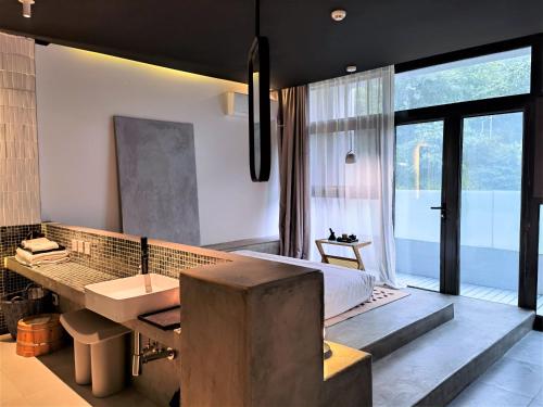 ein Bad mit einem Bett und einem Waschbecken in einem Zimmer in der Unterkunft Delight Inn in Yanqing
