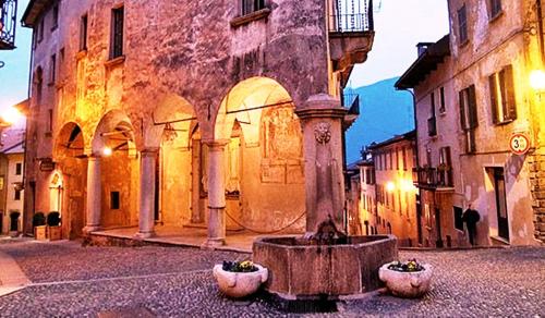 an old building with a fountain in the middle of a street at Lakeview Cannobio Camping & Resort in Cannobio