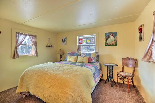 sypialnia z łóżkiem i stołem oraz 2 oknami w obiekcie Colorado Vacation Rental with Deck and Mtn Views w mieście Cripple Creek