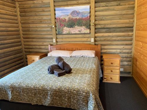 a bedroom with a bed in a wooden cabin at Happy Wanderer Holiday Resort The Grampians in Wartook