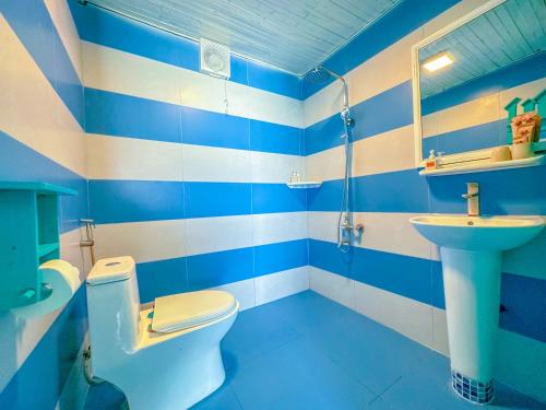 een blauwe en witte badkamer met een toilet en een wastafel bij Paradise Resort Doc Let in Doc Let