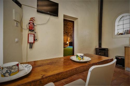 a dining room with a wooden table with two cups on it at Casa Bi Rosario - Quinta Amoreira in Faro