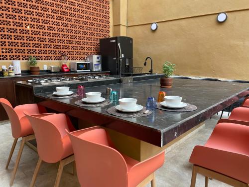 メキシコシティにあるColmena Hotel CDMX Centroのキッチン(椅子とテーブル付きのカウンター付)