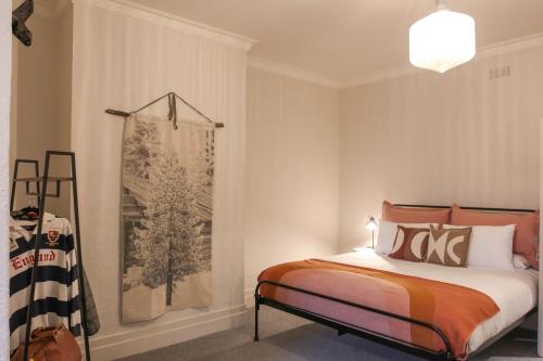 1 dormitorio con 1 cama y una pintura en la pared en Alpine Hotel, Eat Drink Sleep en Warburton