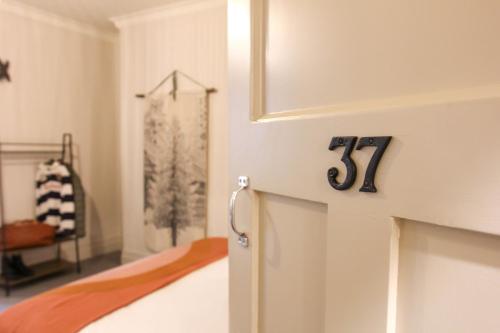 a bedroom with a bed with a number on the wall at Alpine Hotel, Eat Drink Sleep in Warburton