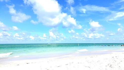 a group of people swimming in the ocean on a beach at Beautiful Waterfront Home Less Than 7 mins to Beaches in Englewood