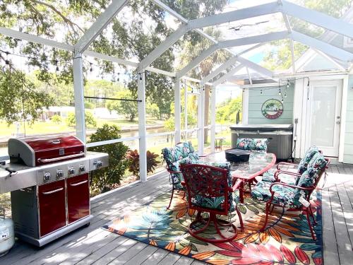 un patio con mesa y sillas bajo una pérgola blanca en Beautiful Waterfront Home Less Than 7 mins to Beaches, en Englewood