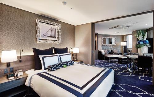 a hotel room with a large bed and a living room at Kent Hotel Gwangalli by Kensington in Busan