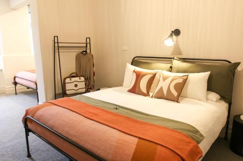 a bedroom with a bed with pillows and a suitcase at Alpine Hotel, Eat Drink Sleep in Warburton