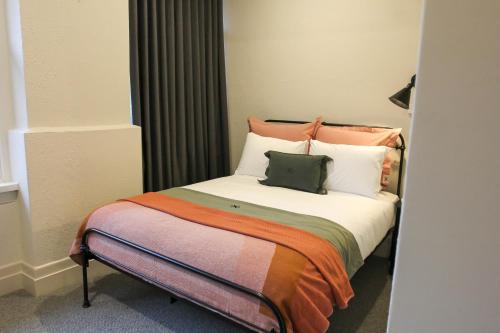 a bedroom with a large bed with pillows at Alpine Hotel, Eat Drink Sleep in Warburton