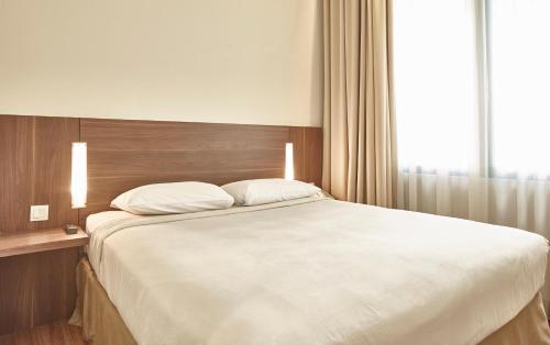 Ένα ή περισσότερα κρεβάτια σε δωμάτιο στο Grand Cikarang Hotel