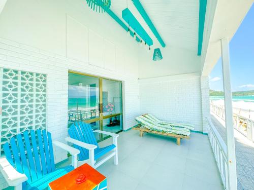 a porch with two blue chairs and a bench at Paradise Resort Doc Let - All Inclusive in Doc Let