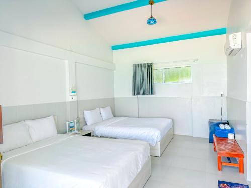 a bedroom with two beds and a red chair at Paradise Resort Doc Let - All Inclusive in Doc Let