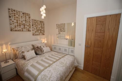 a bedroom with a bed and a wooden door at Edinburgh Pearl Apartments - Dalry House Residence in Edinburgh