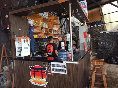 un grupo de personas de pie en un bar en Welirang Forest Pacet en Mojokerto