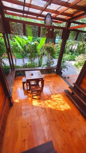 a screened in porch with a table and a bench at Areeya phubeach resort wooden house Coliving Coworking in Ban Chong Phli