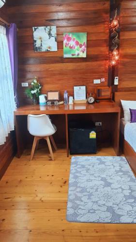 a bedroom with a desk with a chair and a bed at Areeya phubeach resort wooden house Coliving Coworking in Ban Chong Phli