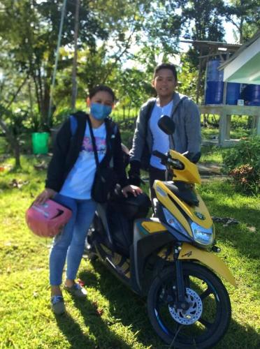 a man and a woman standing next to a motorcycle at House of TamSe Laagans ' Inn in Badian