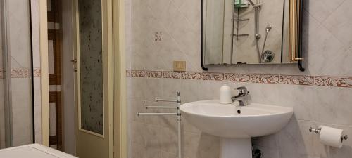 uma casa de banho com um lavatório e um espelho em Cisanello Room Rent em Pisa