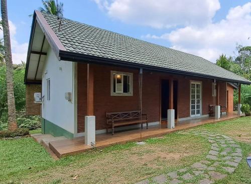 una piccola casa con una terrazza in legno in un cortile di Victoria Views Resort Kandy a Digana