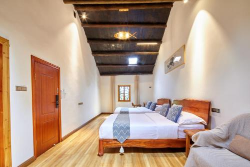 a bedroom with a large bed and a wooden floor at Yangshuo Yunshe Mountain Guesthouse in Yangshuo