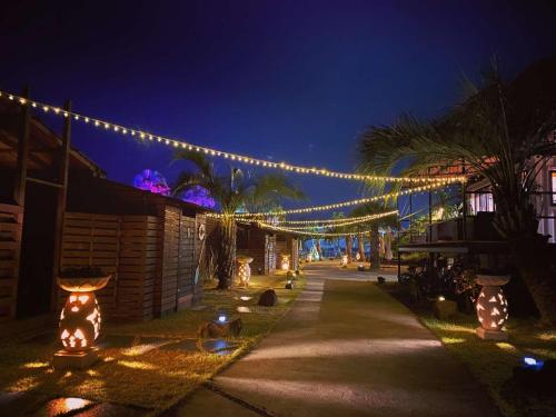 a string of lights hanging over a sidewalk at night at Glamping village Seagrand in Matsuura