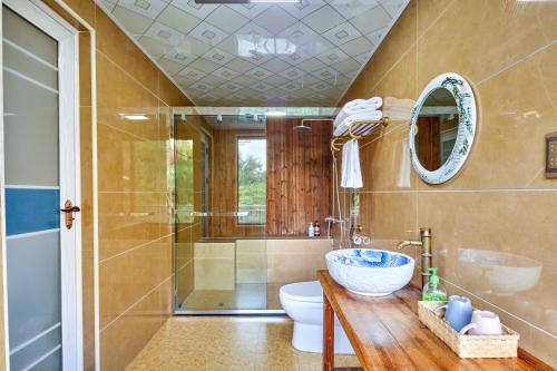 a bathroom with a shower and a toilet and a sink at Yangshuo Yunshe Mountain Guesthouse in Yangshuo