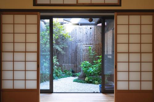 eine offene Tür mit einem Garten im Freien in der Unterkunft Kyomachi Yumeji in Kyoto