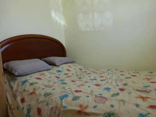 uma cama com um edredão e almofadas em Appartement Saint-Hilaire-de-Riez, 2 pièces, 2 personnes - FR-1-224-119 em Saint-Hilaire-de-Riez