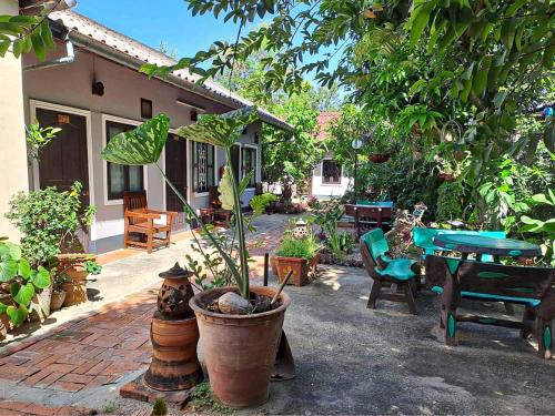 a patio with a table and a potted plant at Chaliya Boutique Garden in Luang Prabang