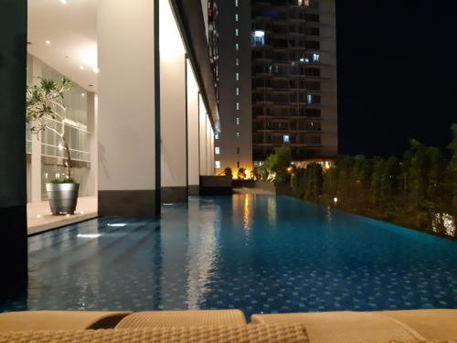- une grande piscine dans un bâtiment la nuit dans l'établissement Apartment Breeze Bintaro, Tangerang Selatan, à Pondoklang
