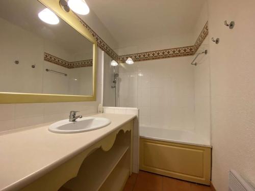 une salle de bain avec un lavabo, une baignoire et un miroir dans l'établissement Les Issambres, T2 avec piscine, parking sécurisé - FR-1-226-467, à Roquebrune-sur Argens