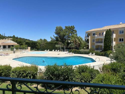 une grande piscine avec des chaises et un bâtiment dans l'établissement Les Issambres, T2 avec piscine, parking sécurisé - FR-1-226-467, à Roquebrune-sur Argens
