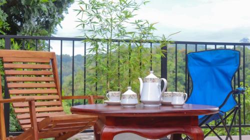 a table with two chairs and a tea set on it at Hideaway Homestay kandy in Haloluwa
