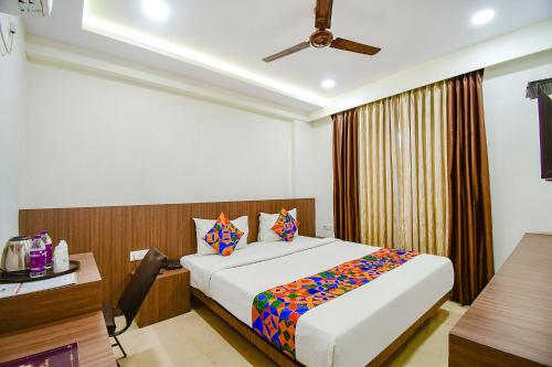 a hotel room with a bed and a desk at FabHotel Kzar Select in Kolkata