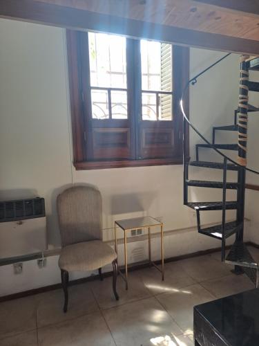sala de estar con silla y escalera de caracol en Confortable para dos en Buenos Aires
