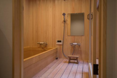 Un baño con bañera, lavabo y espejo. en Kyomachi Rakunan, en Kioto