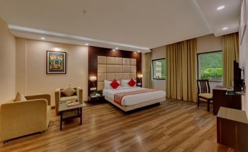 a bedroom with a bed and a desk and a chair at Spectrum Resort & Spa in Udaipur
