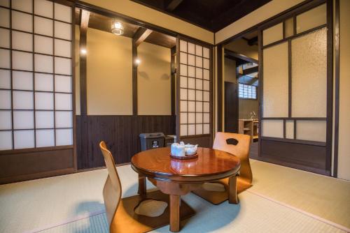 a dining room with a wooden table and chairs at Kyomachi Rakunan in Kyoto