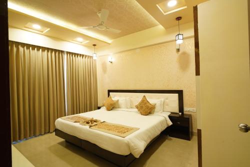 a bedroom with a large white bed with curtains at Spectrum Resort, Spa & Residences in Udaipur