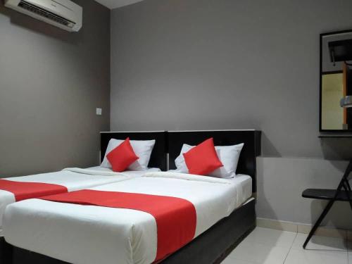a bedroom with a large bed with red and white pillows at HOTEL AVATARR in Batu Caves