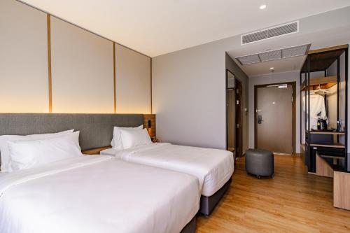 a hotel room with two beds and a television at Best Western Chatuchak in Bangkok