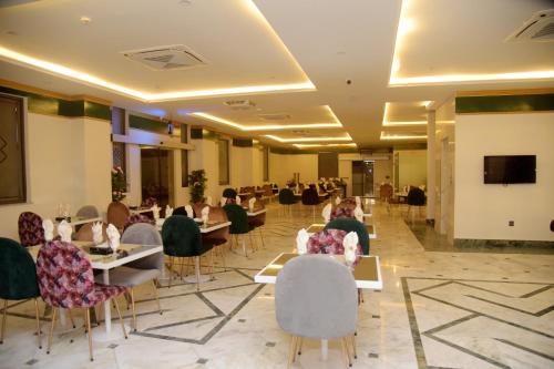 The Rich Hotel & Apartments في لاهور: غرفة طعام مع أشخاص يجلسون على الطاولات