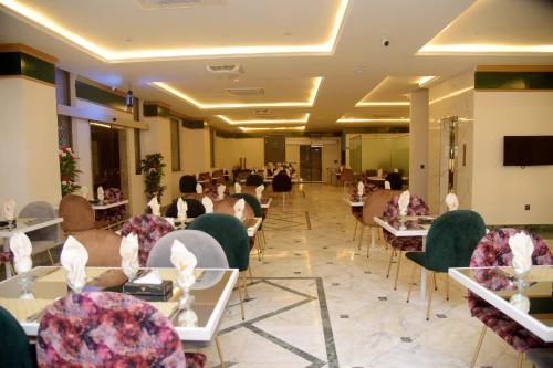 a restaurant with tables and chairs with people sitting at them at The Rich Hotel & Apartments in Lahore